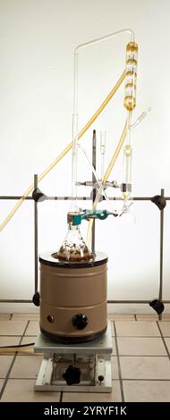 Configuration de laboratoire montrant l'ébullition de réaction chimique dans la verrerie, connecté à un condenseur pour le refroidissement et la séparation Banque D'Images