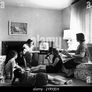 Famille regardant la télévision dans leur maison, c. 1958 Banque D'Images