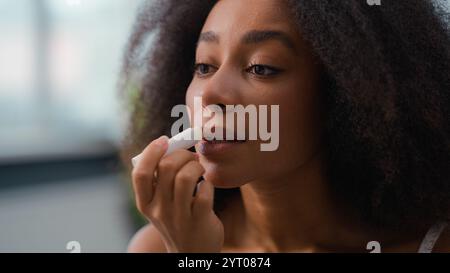 African American Beauty femme routine maquillage appliquer naturel Smooth Moisturize rouge à lèvres ethnique femme biracial Lady Girl appliquant des soins de la peau de baume de lèvres Banque D'Images