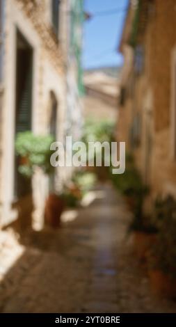 Ruelle défocalisée à majorque avec un fond flou mettant en vedette une rue extérieure pittoresque en espagne sous la lumière du soleil avec chemin pavé et tra Banque D'Images