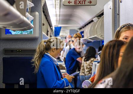 Équipage de cabine et passagers à bord du vol KLM au départ d'Amsterdam Banque D'Images