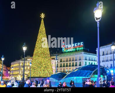 Sapin de Noël doré sur la place Puerta del sol, avec le néon Tio Pepe en arrière-plan. Madrid, Espagne. Banque D'Images