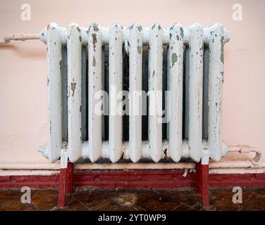 Vieux radiateur de chauffage en fonte avec peinture écaillée Banque D'Images
