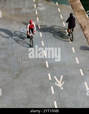 Cyclistes longeant le Paseo Maritimo Santander Cantabrie Espagne à l'ombre du centre artistique Centro Botin Banque D'Images