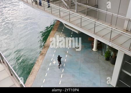 Cyclistes longeant le Paseo Maritimo Santander Cantabrie Espagne à l'ombre du centre artistique Centro Botin Banque D'Images