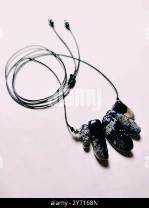 Pierre précieuse en agate noire avec inserts bleus choker. Collier de perles noir cordon irrégulier à fond rose Fermer. Bijoux en pierre naturelle, bijoux en perles Banque D'Images