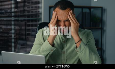 Malsain fatigué afro-américain homme se sentant mal de tête souffrant de migraine chronique épuisé homme d'affaires malade se sentent fatigue après le travail de bureau à Banque D'Images