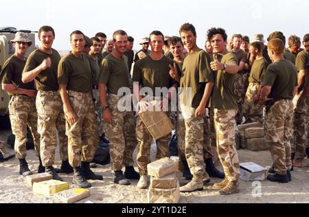 Première Guerre du Golfe : 15 mars 1991 des soldats du 1er Bataillon Scots Guards sont rassemblés à l'arrière d'un FV510 Warrior IFV (Infantry Fighting Vehicle) de l'armée britannique, dans le désert au nord de Koweït City. Ils viennent de recevoir du courrier et des colis de chez eux. Leurs combats terminés, ils se préparent à se retirer du Koweït. Banque D'Images