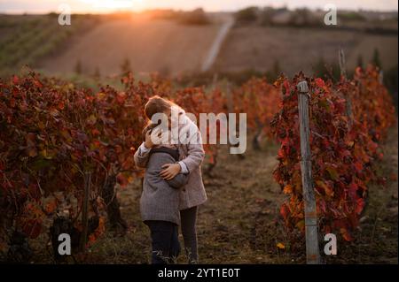 garçon et fille marchent sur le vignoble avec la lumière sur un coucher de soleil Banque D'Images