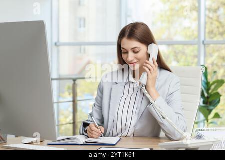 Banquier parlant au téléphone à table dans le bureau Banque D'Images