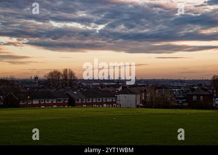 Coucher de soleil sur la ligne d'horizon lointaine de Manchester depuis Clarence Park, Bury, Angleterre. Banque D'Images