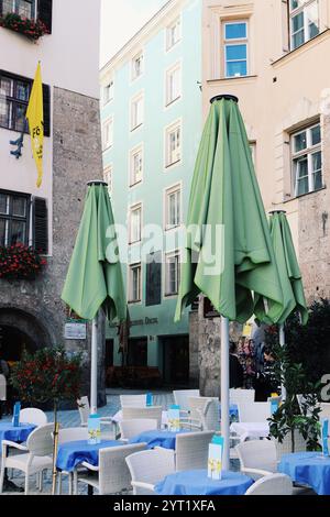 Innsbruck, Autriche - septembre 29 2024 : Café en plein air sur la place historique d'Innsbruck avec parapluies verts fermés Banque D'Images