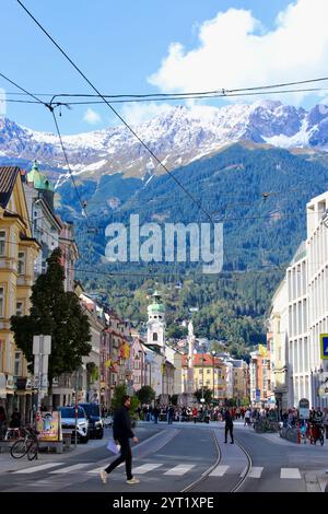 Innsbruck, Autriche - septembre 29 2024 : Innsbruck City Street animée avec son architecture historique et ses montagnes alpines enneigées en arrière-plan Banque D'Images