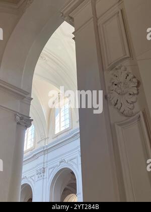 L'intérieur de l'église baroque ensoleillé présente des arches élégantes, des plâtres ornés et des détails architecturaux complexes Banque D'Images