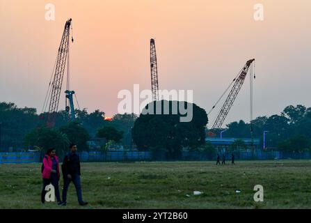 Kolkata, Inde. 05th Dec, 2024. Un couple se promène dans le quartier de Maidan, un parc urbain où les travaux de construction du métro sont visibles en arrière-plan. (Photo de Dipayan Bose/SOPA images/SIPA USA) crédit : SIPA USA/Alamy Live News Banque D'Images