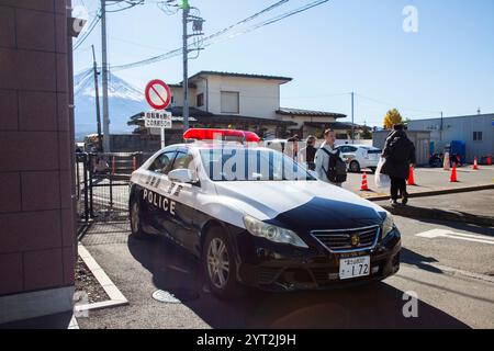 Voiture de police japonaise garée dans une route secondaire à Kawaguchiko avec le mont Fuji en arrière-plan par une journée ensoleillée claire. Banque D'Images