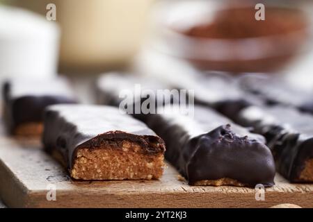 Barres saines faites maison sans cuisson à base de poudre de protéines de lactosérum, beurre d'arachide et dattes enrobées de chocolat, gros plan Banque D'Images