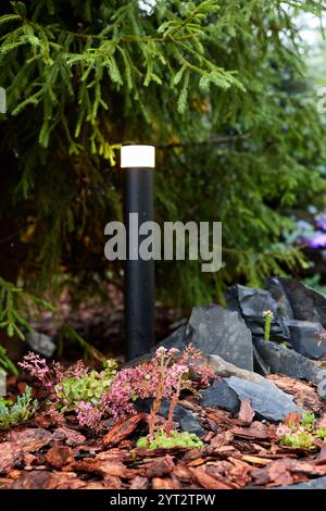 Explorez l'éclairage de jardin moderne qui intègre de beaux éléments naturels pour le style et l'ambiance Banque D'Images