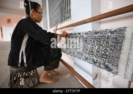 (241206) -- PÉKIN, 6 décembre 2024 (Xinhua) -- Fu Yongying, un héritier provincial des techniques textiles traditionnelles Li, démontre ses compétences dans une salle d'exposition de la ville de Dongfang, province de Hainan, dans le sud de la Chine, le 6 juin 2023. Trois éléments culturels chinois, à savoir les techniques textiles traditionnelles Li : filature, teinture, tissage et broderie, fête du nouvel an de Qiang, célébrée dans la province chinoise du Sichuan, et la conception et les pratiques traditionnelles pour la construction de ponts en arche en bois chinois, ont été ajoutés par l'UNESCO à sa liste représentative du patrimoine culturel immatériel de l'humanité au cours de l'année Banque D'Images