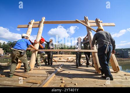 (241206) -- PÉKIN, 6 décembre 2024 (Xinhua) -- les ouvriers travaillent à la restauration du pont Wan'an, un pont en arc de bois, dans le canton de Changqiao du comté de Pingnan, province du Fujian du sud-est de la Chine, 2 novembre 2023. Trois éléments culturels chinois, à savoir les techniques textiles traditionnelles Li : filature, teinture, tissage et broderie, fête du nouvel an de Qiang, célébrée dans la province chinoise du Sichuan, et la conception et les pratiques traditionnelles pour la construction de ponts en arc de bois chinois, ont été ajoutés par l'UNESCO à sa liste représentative du patrimoine culturel immatériel de l'humanité lors de la 19e session du I. Banque D'Images