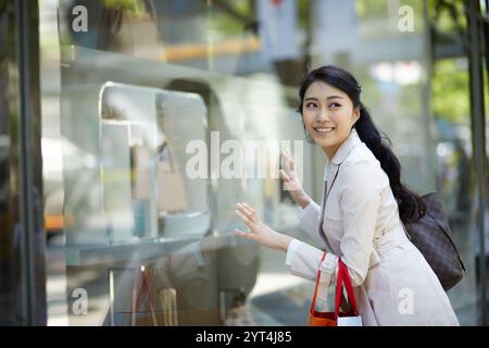 Femme regardant par la fenêtre d'exposition Banque D'Images