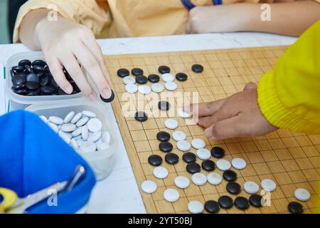 Les gens jouant le jeu de Go planche de grille en bois Banque D'Images