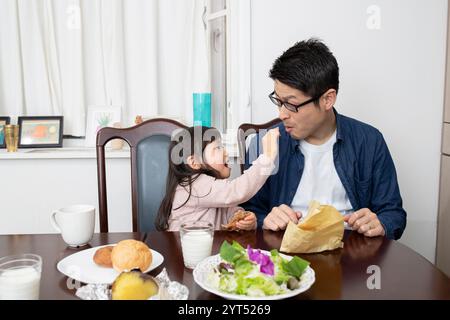 Fille essayant de nourrir son père Banque D'Images