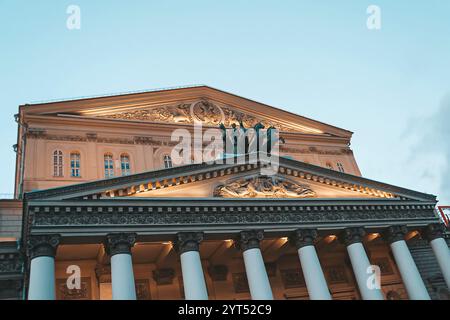 Gros plan de la partie supérieure d'un bâtiment du Théâtre Bolchoï. Grand théâtre à Moscou. Illumination d'un char avec quatre chevaux et Apollon au ciel du soir b Banque D'Images
