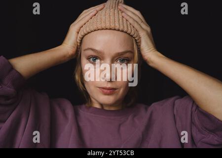 Portrait de personnage émotionnel, jeune femme élégante dans une casquette, gros plan Banque D'Images