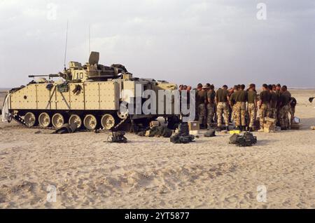 Première Guerre du Golfe : 15 mars 1991 des soldats du 1er Bataillon Scots Guards sont rassemblés à l'arrière d'un FV510 Warrior IFV (Infantry Fighting Vehicle) de l'armée britannique, dans le désert au nord de Koweït City. Ils viennent de recevoir du courrier et des colis de chez eux. Leurs combats terminés, ils se préparent à se retirer du Koweït. Banque D'Images