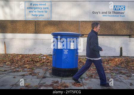 Londres, Royaume-Uni. 6 décembre 2024 Un piéton passe devant une boîte aux lettres peinte en bleu comme un merci au NHS devant l'hôpital St Thomas à Westminster. Le NHS est confronté à un quadruple-demic de santé cet hiver car le nombre de personnes hospitalisées pour la grippe a augmenté de 350%, ce qui met une pression significative sur le NHS en raison de la hausse des cas de grippe et de covid par rapport à l’année dernière crédit. Amer Ghazzal/Alamy Live News Banque D'Images