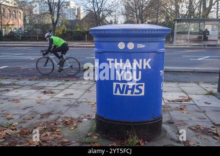 Londres, Royaume-Uni. 6 décembre 2024 Un piéton passe devant une boîte aux lettres peinte en bleu comme un merci au NHS devant l'hôpital St Thomas à Westminster. Le NHS est confronté à un quadruple-demic de santé cet hiver car le nombre de personnes hospitalisées pour la grippe a augmenté de 350%, ce qui met une pression significative sur le NHS en raison de la hausse des cas de grippe et de covid par rapport à l’année dernière crédit. Amer Ghazzal/Alamy Live News Banque D'Images