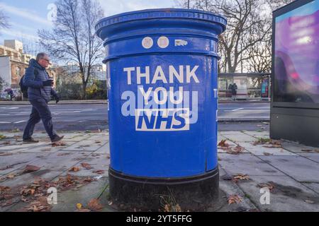 Londres, Royaume-Uni. 6 décembre 2024 Un piéton passe devant une boîte aux lettres peinte en bleu comme un merci au NHS devant l'hôpital St Thomas à Westminster. Le NHS est confronté à un quadruple-demic de santé cet hiver car le nombre de personnes hospitalisées pour la grippe a augmenté de 350%, ce qui met une pression significative sur le NHS en raison de la hausse des cas de grippe et de covid par rapport à l’année dernière crédit. Amer Ghazzal/Alamy Live News Banque D'Images