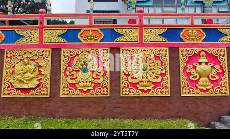 Sculptures détaillées de symboles bouddhistes sacrés ornant les murs du monastère Khinmey Nyingma, Tawang, Arunachal Pradesh, Inde. Banque D'Images