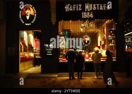 Istanbul, Turquie - 1er décembre 2024 : la vue de face de la boutique Hafiz Mustafa 1864 la nuit, les célèbres bonbons traditionnels turcs ravissent Banque D'Images