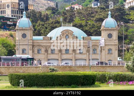 Bakou, Azerbaïdjan - 4 mai 2024 : la caserne de pompiers historique, avec son architecture impressionnante, attire les visiteurs au milieu de fleurs printanières vibrantes et de verdure Banque D'Images