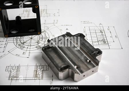 Les prototypes en plastique et en métal reposent sur un dessin technique avec des mesures, illustrant le processus de développement du produit. Banque D'Images