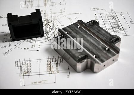 Les prototypes en plastique et en métal reposent sur un dessin technique avec des mesures, illustrant le processus de développement du produit. Banque D'Images