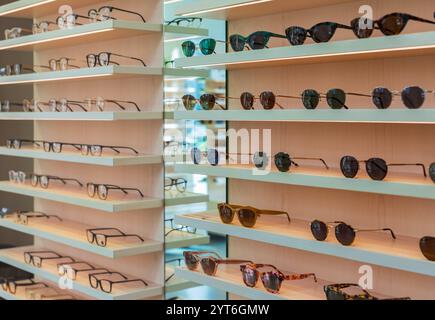 Étagères Storefront de diverses lunettes de soleil modernes dans le magasin de détail. Présentoir plein de lunettes de soleil. Tenez-vous debout avec des lunettes de soleil. Lunettes de soleil tendance à la mode Banque D'Images