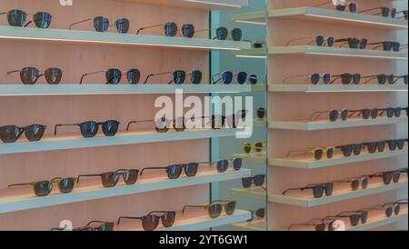 Étagères Storefront de diverses lunettes de soleil modernes dans le magasin de détail. Présentoir plein de lunettes de soleil. Tenez-vous debout avec des lunettes de soleil. Lunettes de soleil tendance à la mode Banque D'Images