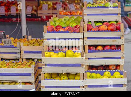 Piles de pommes colorées et de fruits de poires jaunes dans des caisses au marché des fermiers Banque D'Images