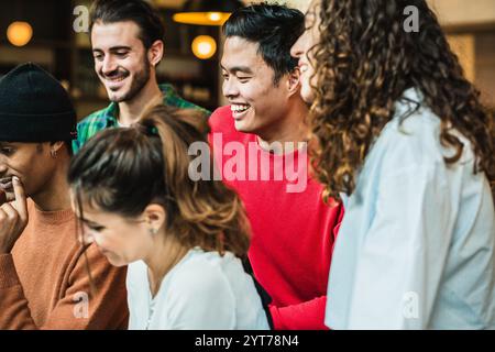 Des étudiants universitaires joyeux collaborent sur un projet, apprécient leur temps ensemble et sourient Banque D'Images