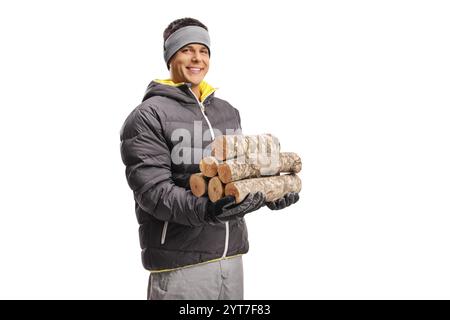 Homme dans un manteau d'hiver tenant un tas de bois de chauffage isolé sur fond blanc Banque D'Images