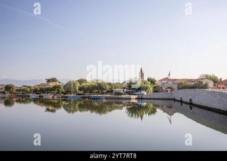 Horizon d'une petite ville méditerranéenne, centre-ville historique avec des remparts massifs sur une île dans une baie ou un lagon. Ambiance matinale à Nin, Zadar, Dalmatie, Croatie, mer Adriatique Banque D'Images