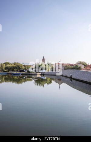 Horizon d'une petite ville méditerranéenne, centre-ville historique avec des remparts massifs sur une île dans une baie ou un lagon. Ambiance matinale à Nin, Zadar, Dalmatie, Croatie, mer Adriatique Banque D'Images