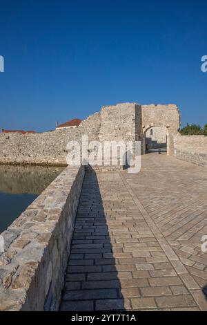 Horizon d'une petite ville méditerranéenne, centre-ville historique avec des remparts massifs sur une île dans une baie ou un lagon. Ambiance matinale à Nin, Zadar, Dalmatie, Croatie, mer Adriatique Banque D'Images