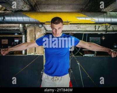 Homme avec T-shirt bleu dans la pièce du sous-sol Banque D'Images