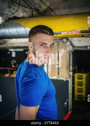 Homme avec T-shirt bleu dans la pièce du sous-sol Banque D'Images