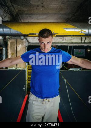 Homme avec T-shirt bleu dans la pièce du sous-sol Banque D'Images