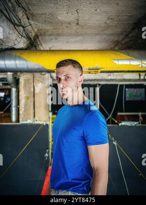 Homme avec T-shirt bleu dans la pièce du sous-sol Banque D'Images